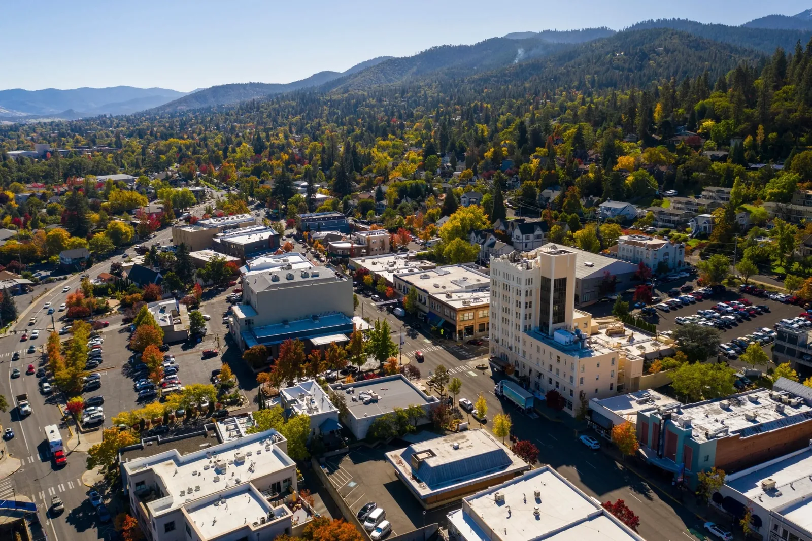 Aerial view of downtown Ashland, Oregon with tree-lined streets and surrounding hills
